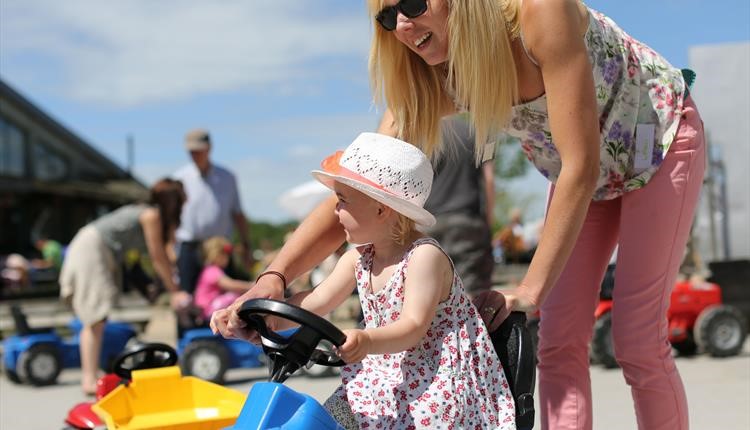 Mother pushing her child around at Farmer Palmers 